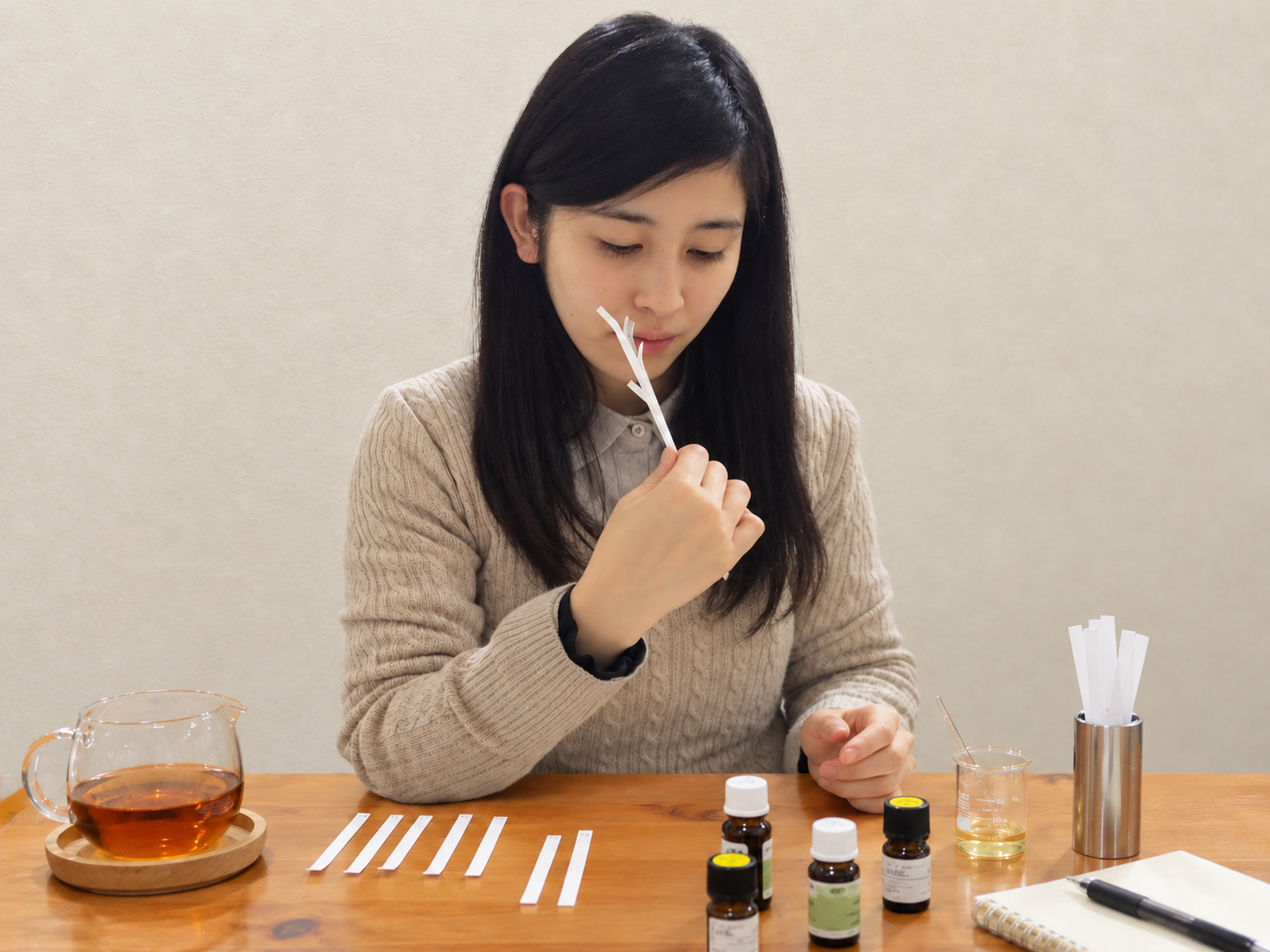 試香紙で香りを確かめる香水作り調合体験の参加者（背景・卓上合成）